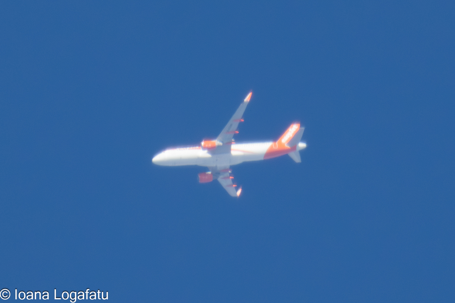 Airplane gliding through a clear blue sky